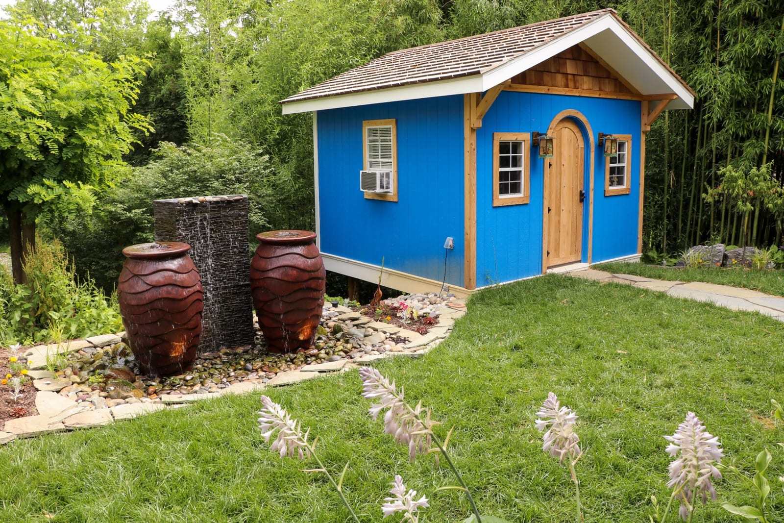 Twin urn fountains beside a blue garden shed by AquaReale Philadelphia