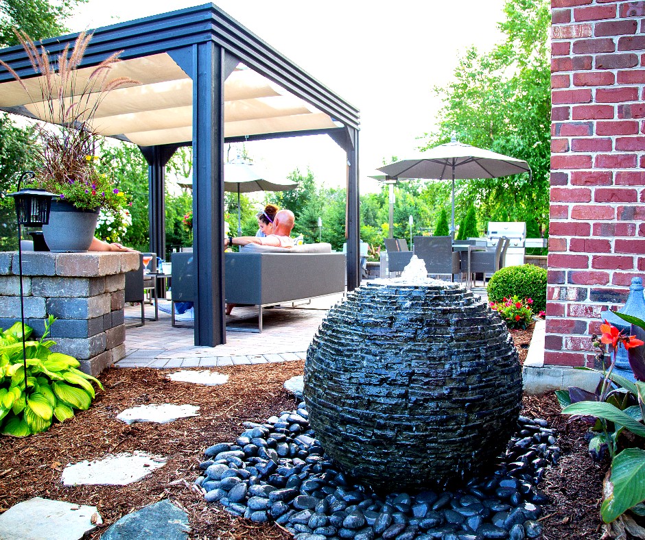 Stacked slate sphere fountain beside a covered patio lounge by AquaReale Philadelphia