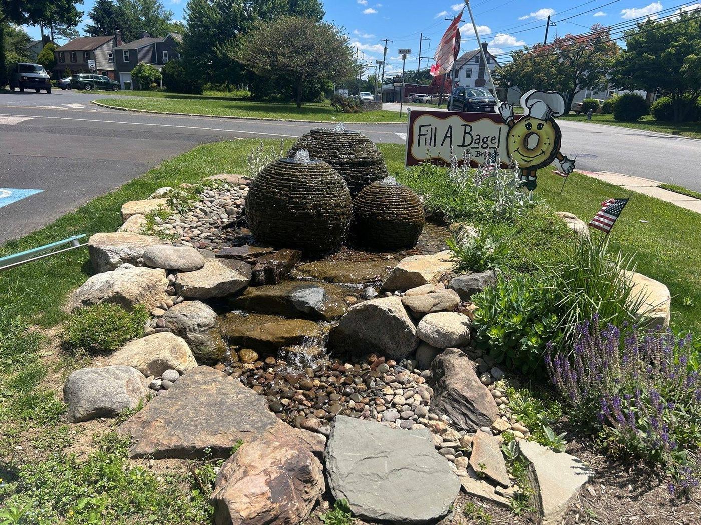 Commercial disappearing water feature with stacked stone spheres at a storefront by AquaReale Philadelphia