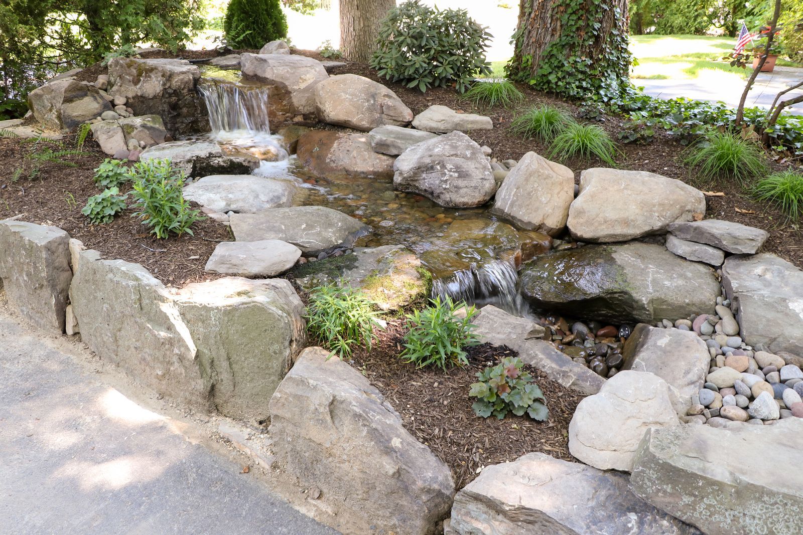 Disappearing waterfall stream running down a landscaped hillside by AquaReale Philadelphia