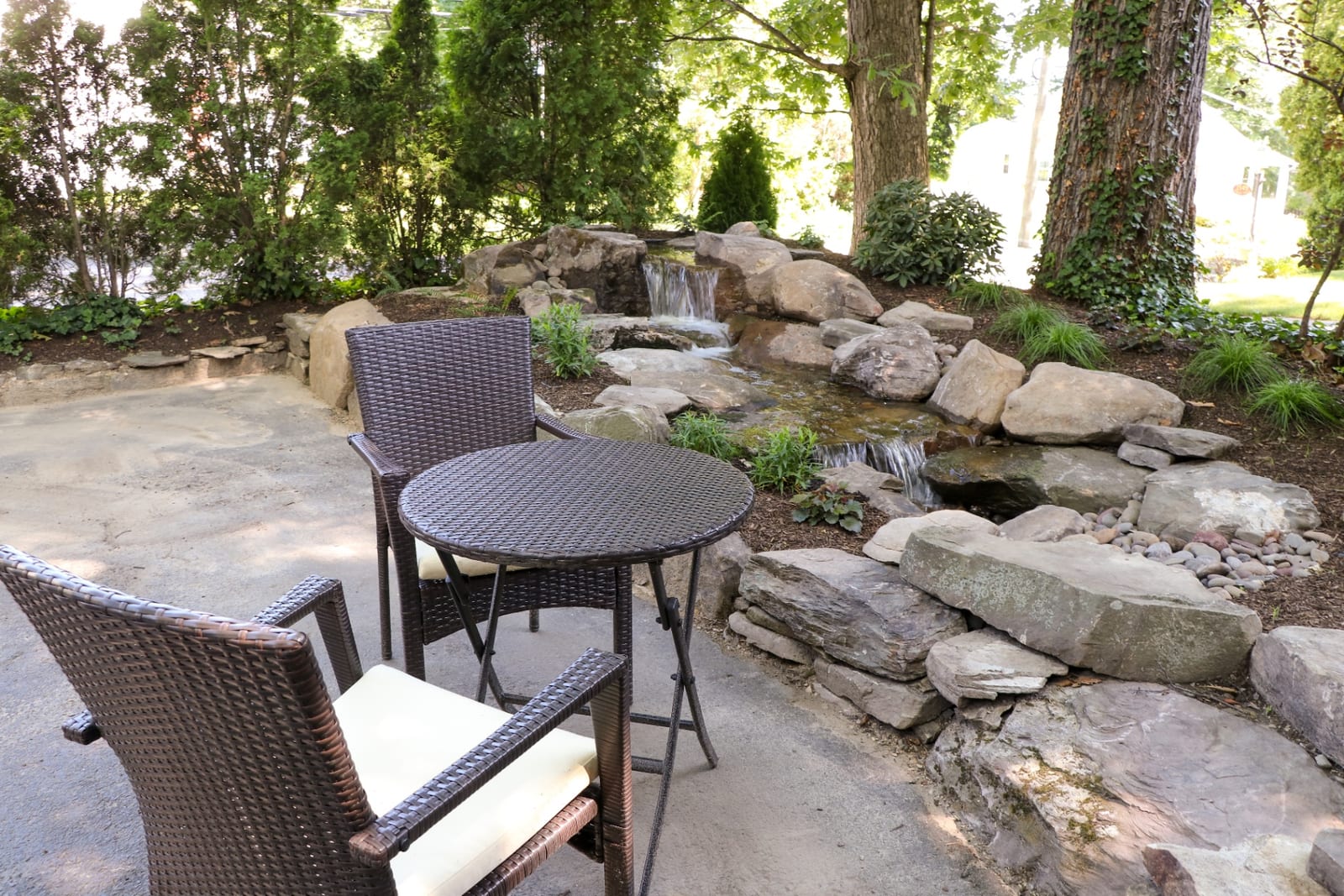 Patio seating beside a disappearing waterfall and stream by AquaReale Philadelphia