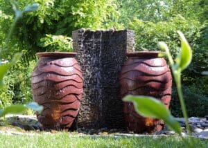 Garden water feature with decorative urns and waterfall.